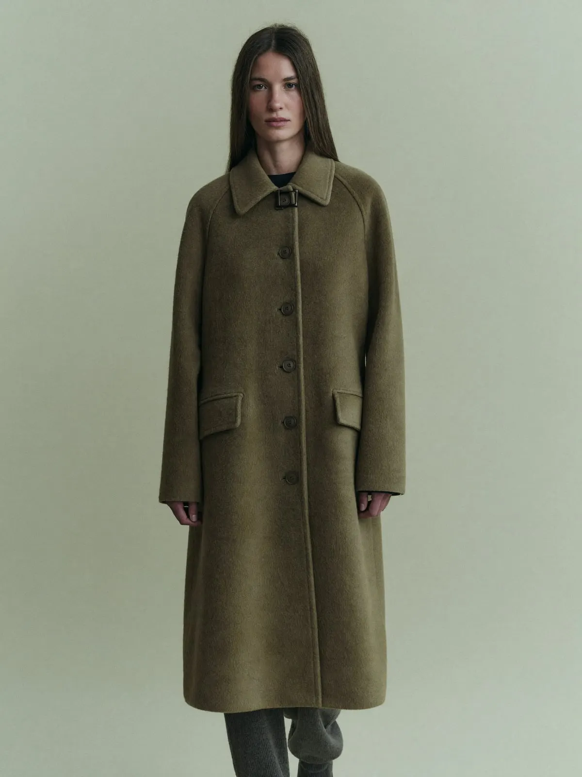 Studio portrait of a woman in an olive coat